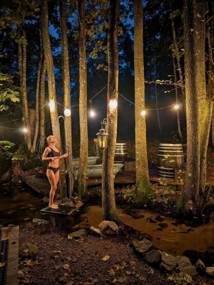 Woman taking cold shower after hot sauna session in one of the best saunas in Norway
